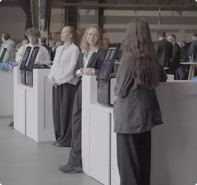 Attendees checking in at self-service kiosks in a conference hall